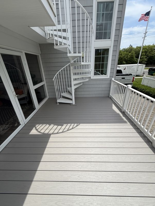 Gray composite deck with white railings and a spiral stair to the upper balcony