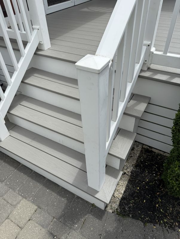 Refreshed deck stairs with gray composite treads and white risers and railings